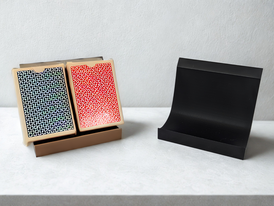 Two boxes with patterned designs on a brown stand. An empty black stand shaped like a smooth L.